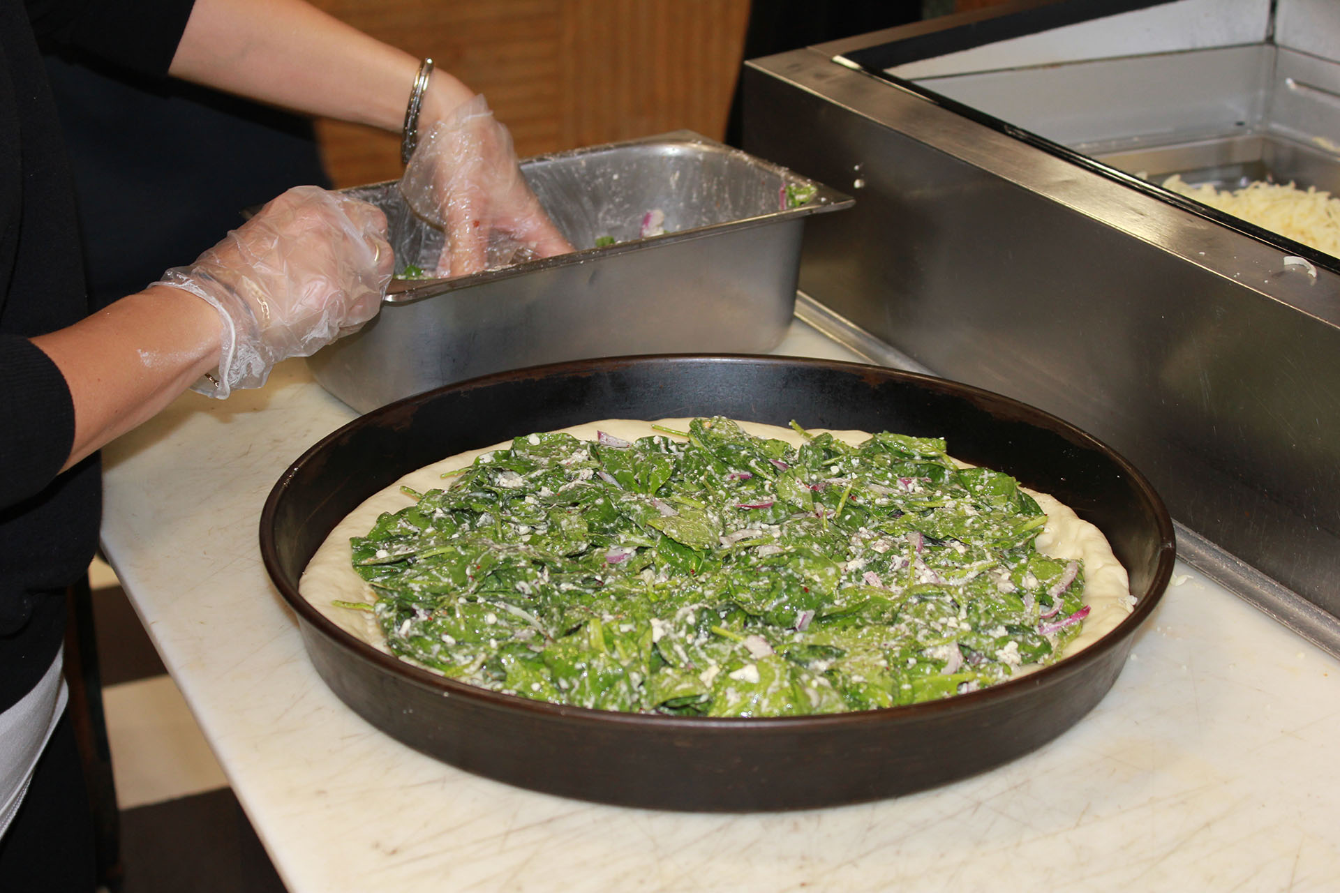 Making the Mediterranean Pizza.